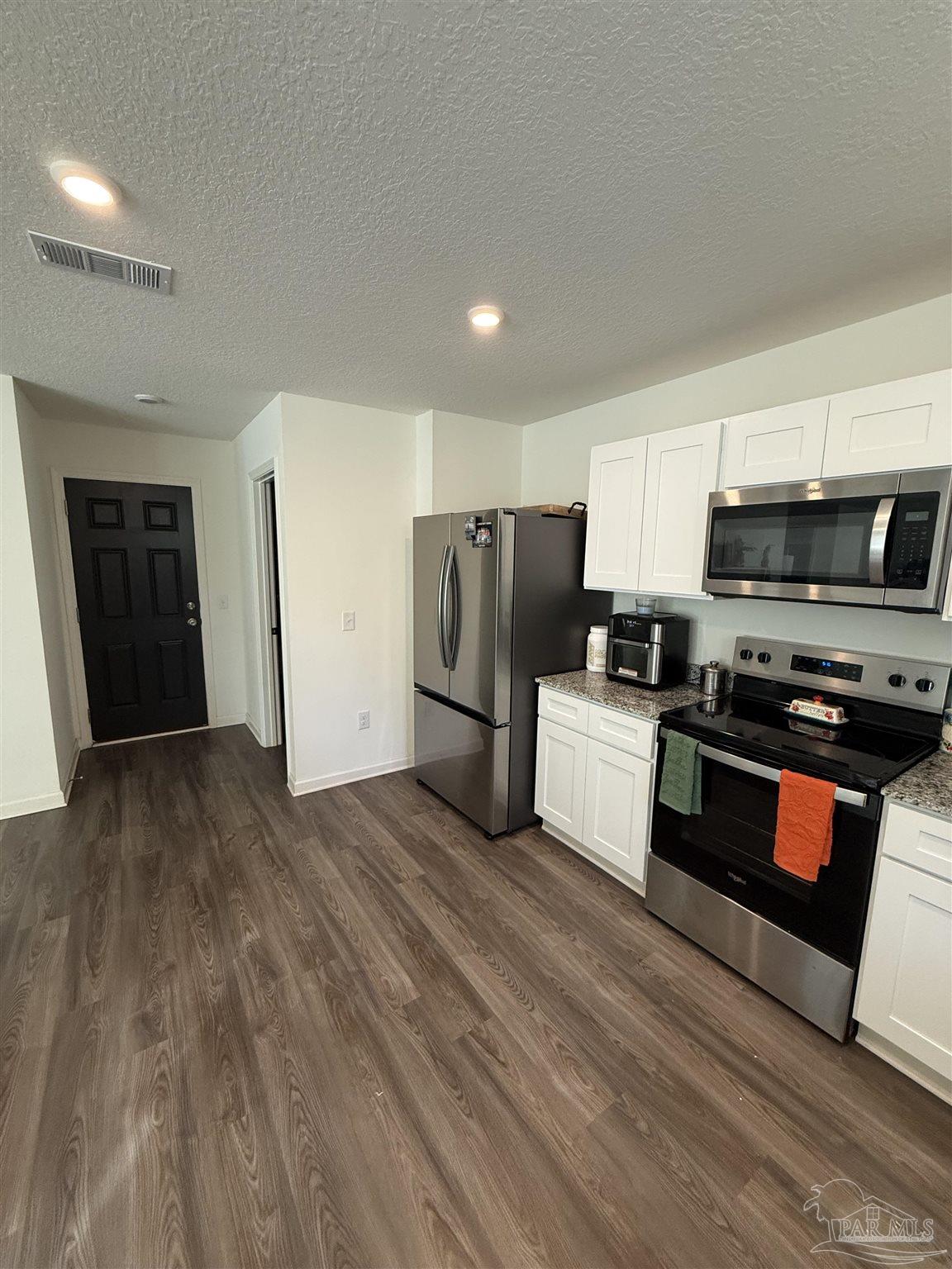 9279 3 Hollow Road Jay, FL 32565 - Photo 5 of 42 a kitchen with stainless steel appliances a refrigerator and a stove top oven