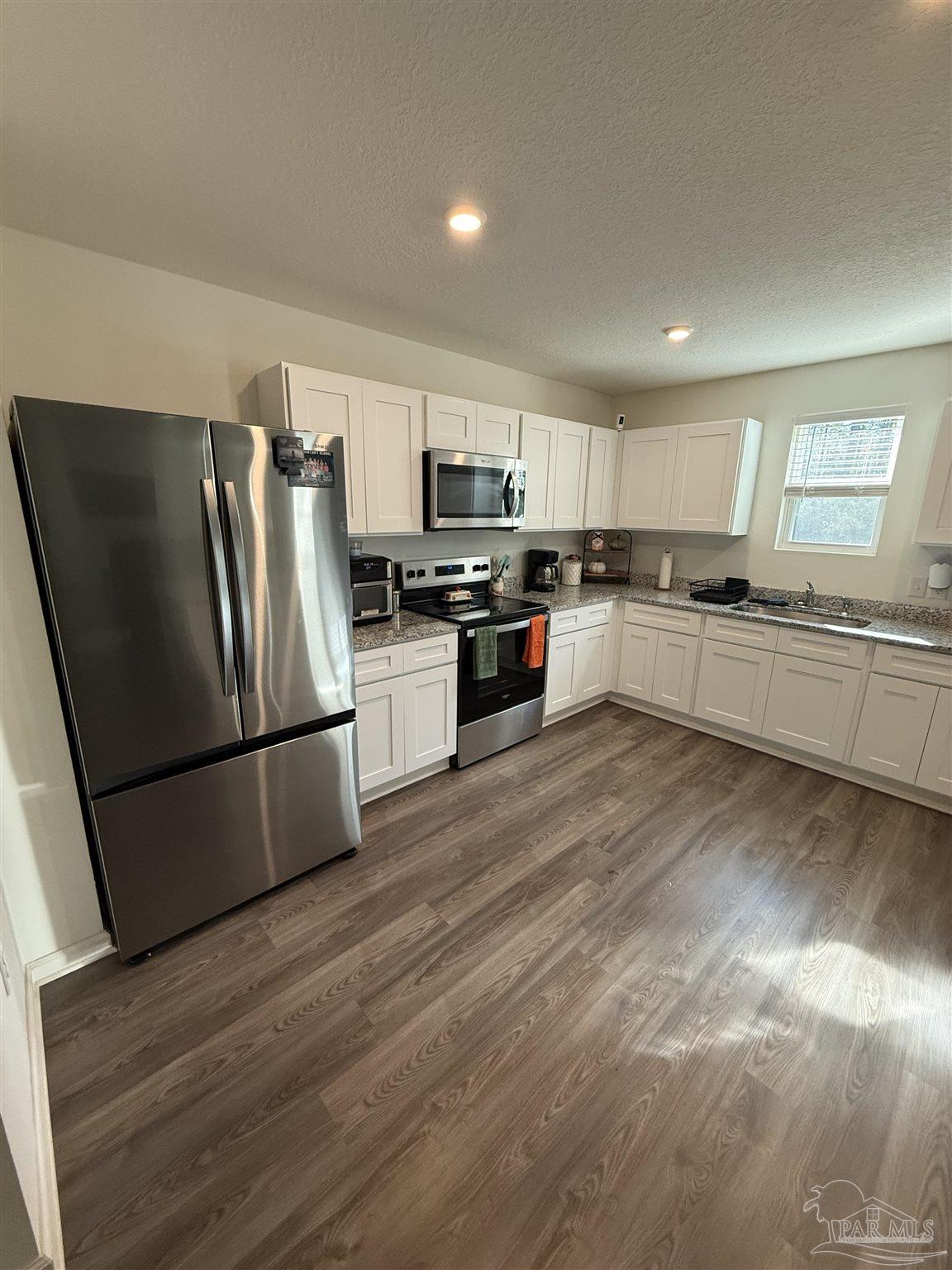 9279 3 Hollow Road Jay, FL 32565 - Photo 9 of 42 a kitchen with granite countertop a refrigerator stove top oven and sink