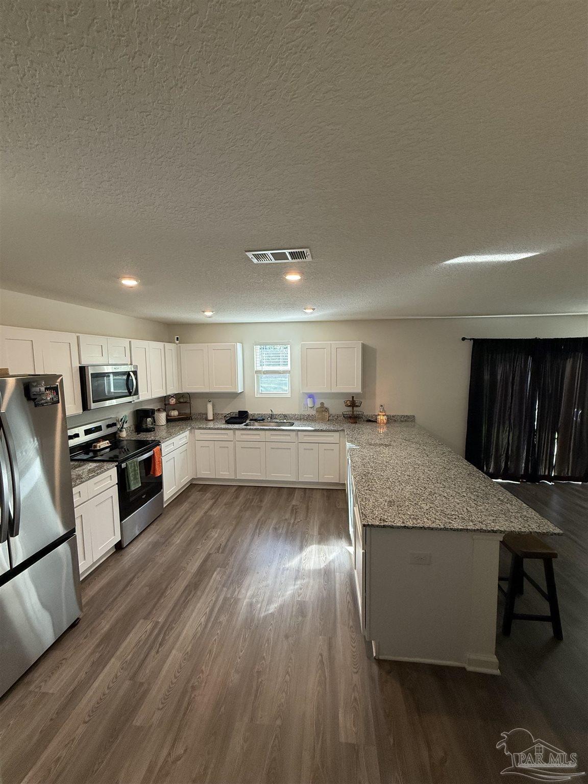 9279 3 Hollow Road Jay, FL 32565 - Photo 10 of 42 a kitchen with stainless steel appliances granite countertop a stove and a refrigerator