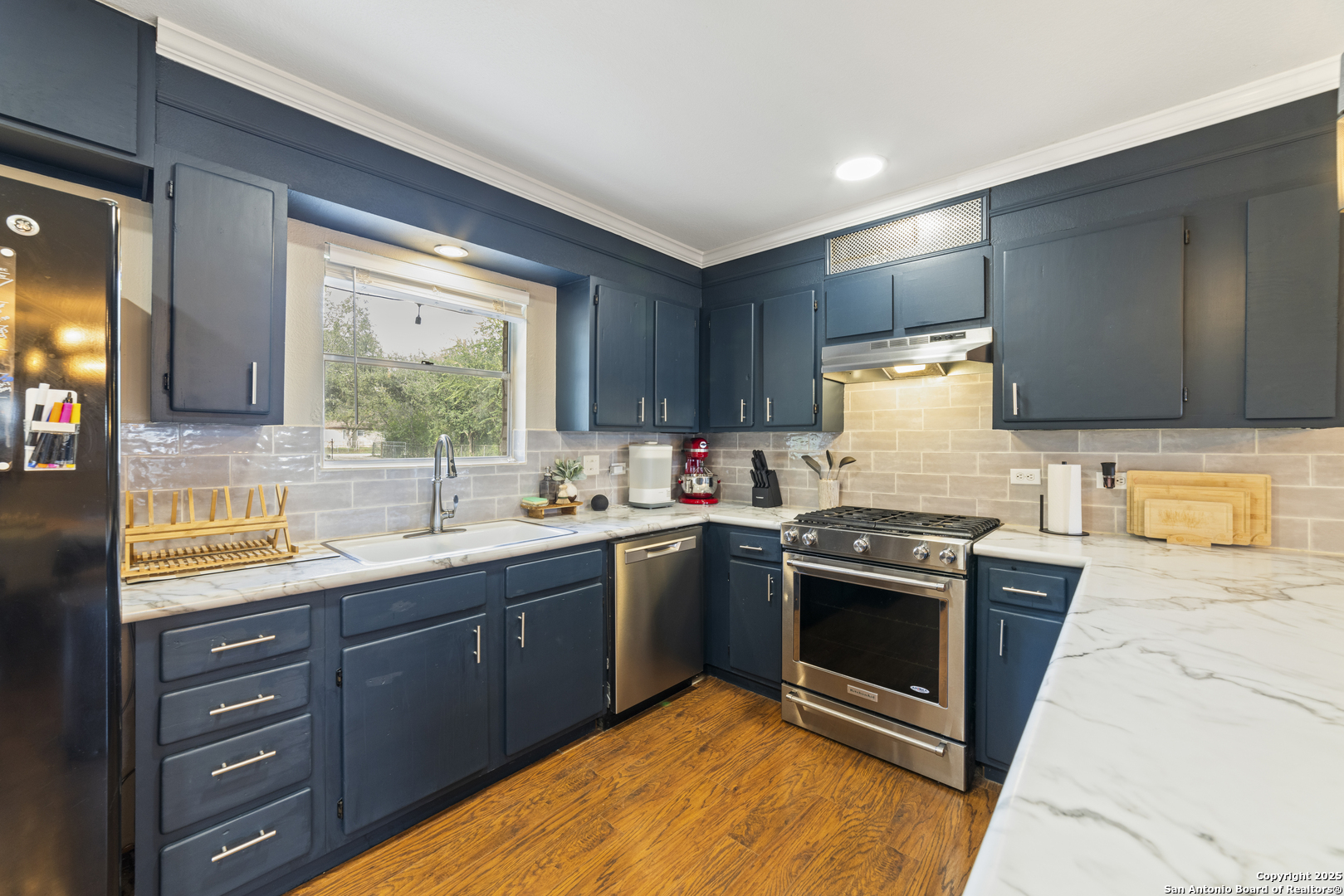 1706 24th Street Hondo, TX 78861 - Photo 14 of 40 a kitchen with stainless steel appliances granite countertop a stove a sink and a refrigerator