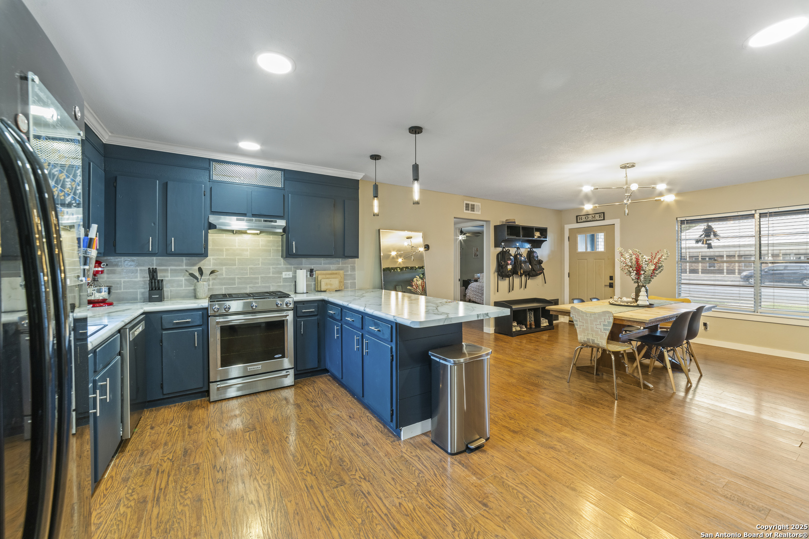 1706 24th Street Hondo, TX 78861 - Photo 15 of 40 a kitchen with stainless steel appliances kitchen island granite countertop a table chairs and a refrigerator