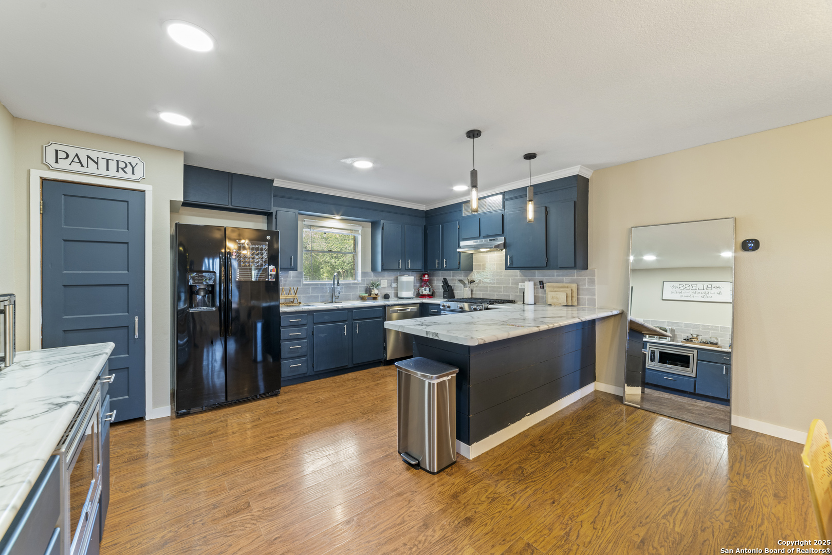 1706 24th Street Hondo, TX 78861 - Photo 17 of 40 a large kitchen with a large counter top stainless steel appliances and wooden floor