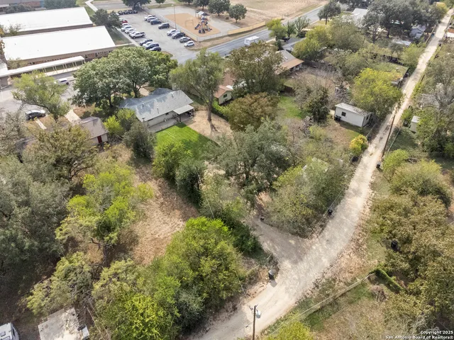 a aerial view of a house with a yard and large trees