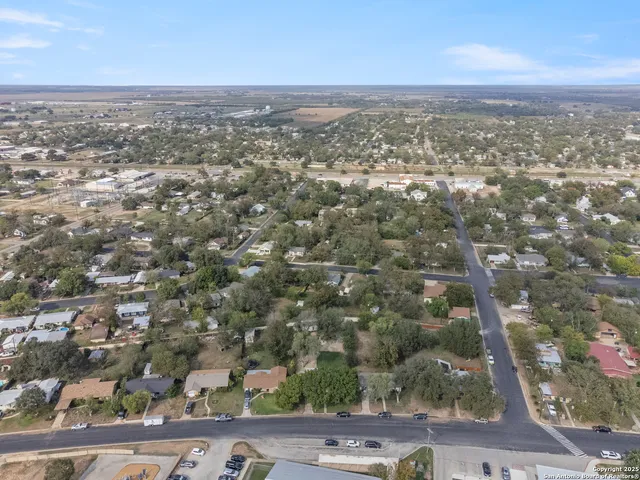 an aerial view of residential houses with outdoor space and trees