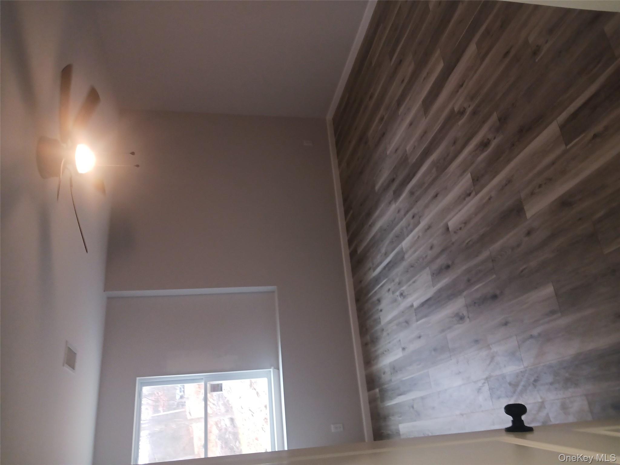 207 Roosa Gap Road Bloomingburg, NY 12721 - Photo 5 of 10 an empty room with wooden floor and windows