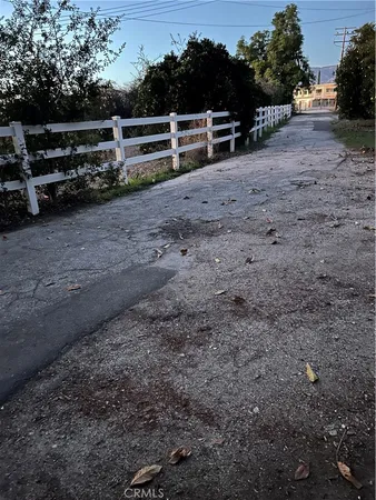 a view of a yard with wooden fence