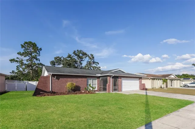 a view of a yard in front of a house with a large tree