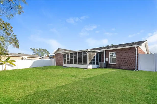 a view of a house with a yard and large trees