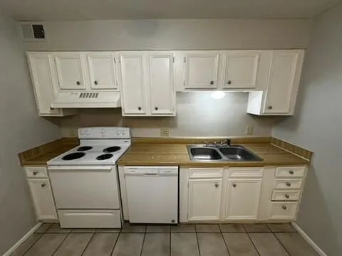 a kitchen with white cabinets and appliances