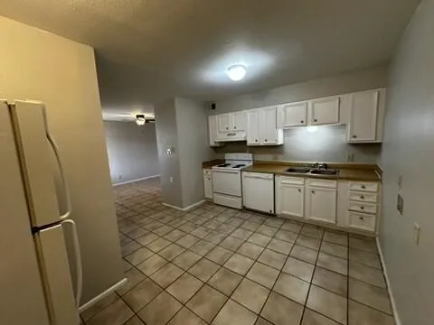 a kitchen with a sink a refrigerator and cabinets