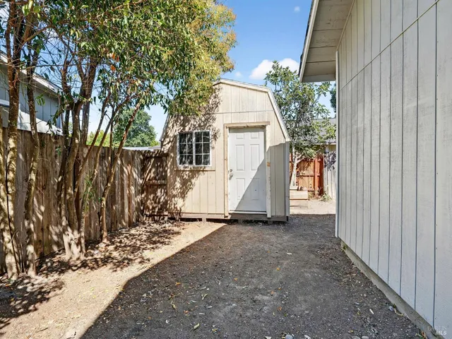a view of a house with backyard and trees