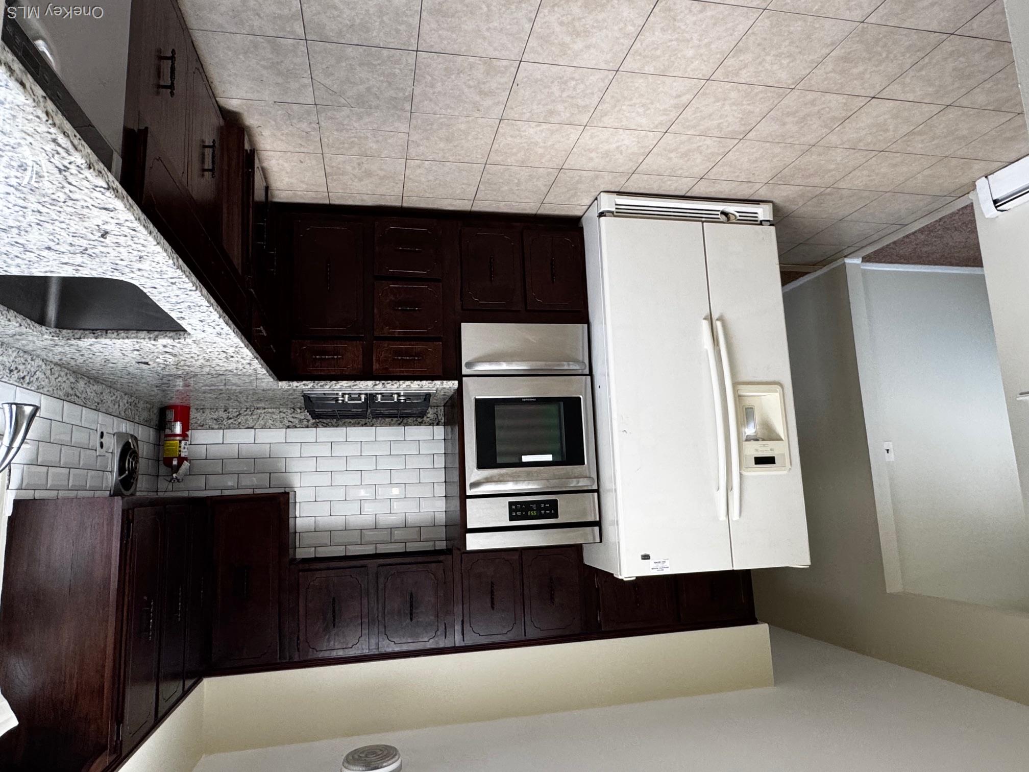 113 Maple Boulevard, Unit UPPR Long Beach, NY 11561 - Photo 2 of 11 a kitchen with a refrigerator sink and cabinets