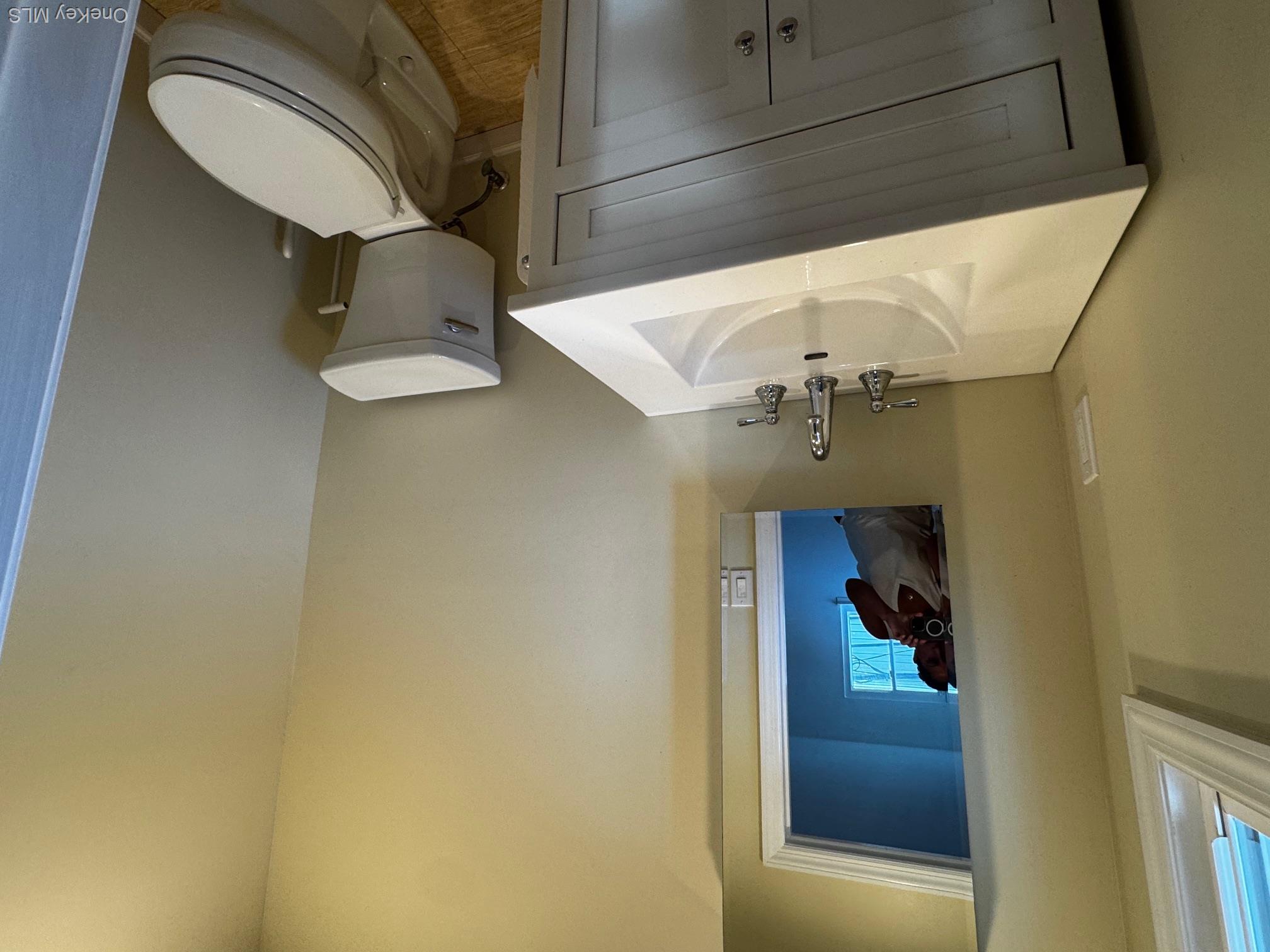 113 Maple Boulevard, Unit UPPR Long Beach, NY 11561 - Photo 8 of 11 a bathroom with a sink a toilet and mirror