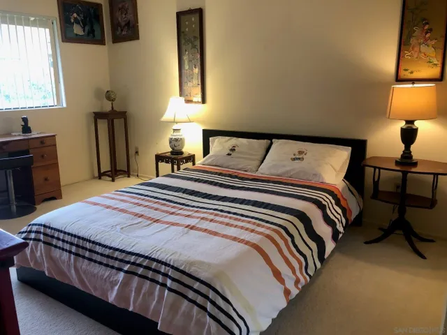 a bedroom with a bed and dresser with mirror