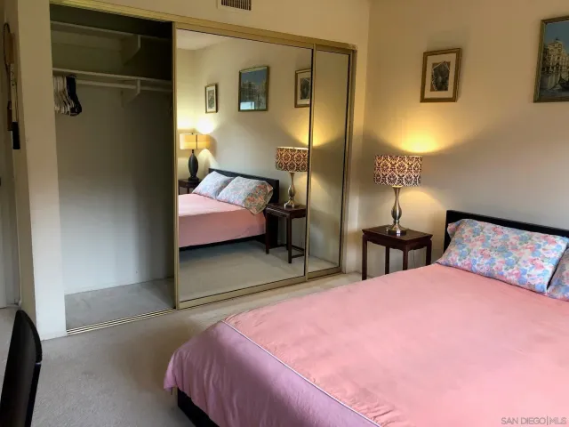 a bedroom with a bed and a lamp with the dresser