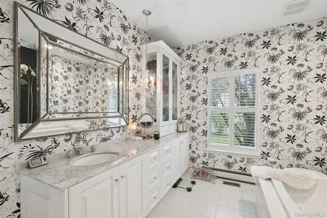 a bathroom with double vanity sink and a bathtub