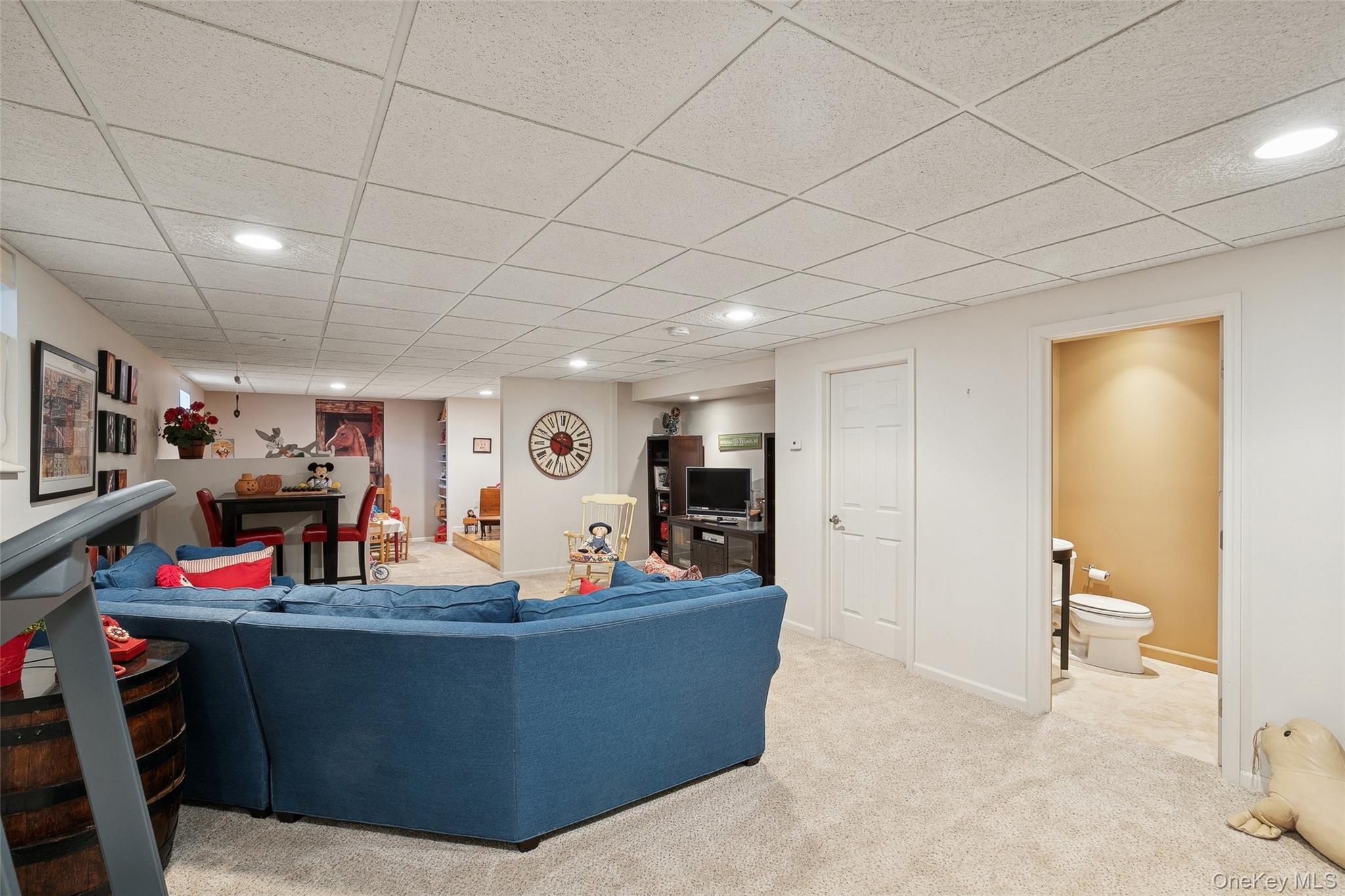 103 Rivendell Court Melville, NY 11747 - Photo 29 of 47 Living room with recessed lighting, a drop ceiling, and light colored carpet