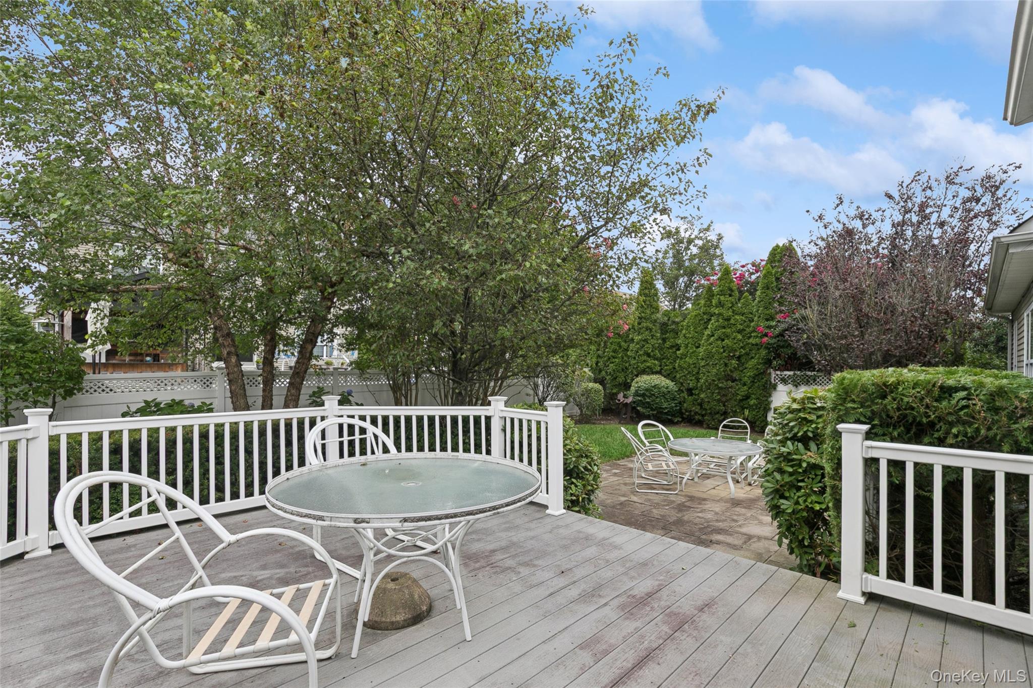 103 Rivendell Court Melville, NY 11747 - Photo 34 of 47 Wooden deck with outdoor dining space, a patio, and a fenced backyard