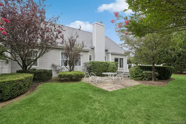 a view of a chair and table in backyard of the house