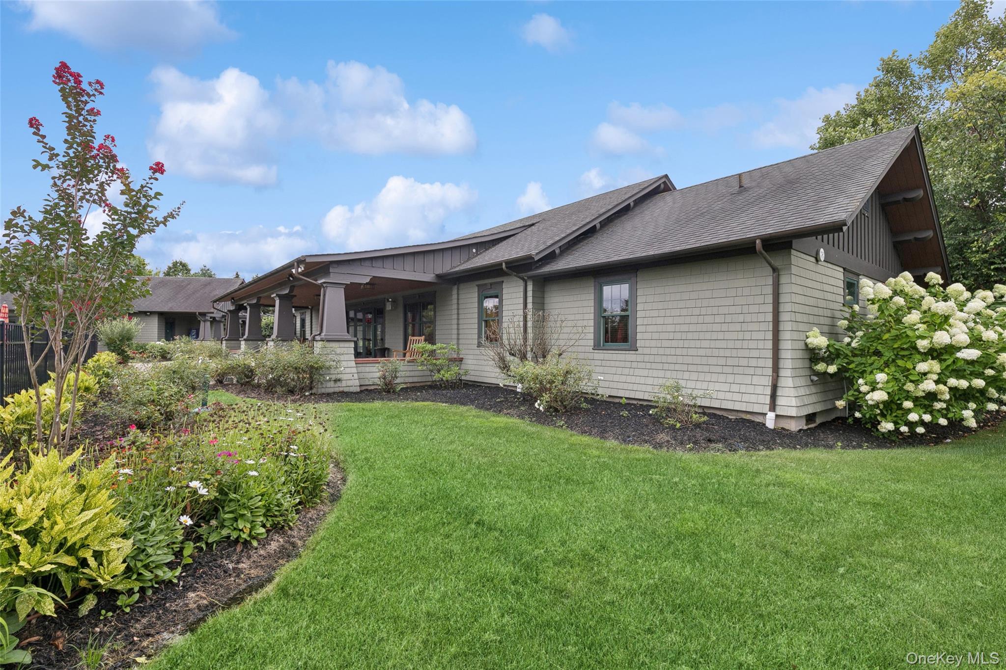 103 Rivendell Court Melville, NY 11747 - Photo 39 of 47 Back of house with a shingled roof, a lawn, and a porch