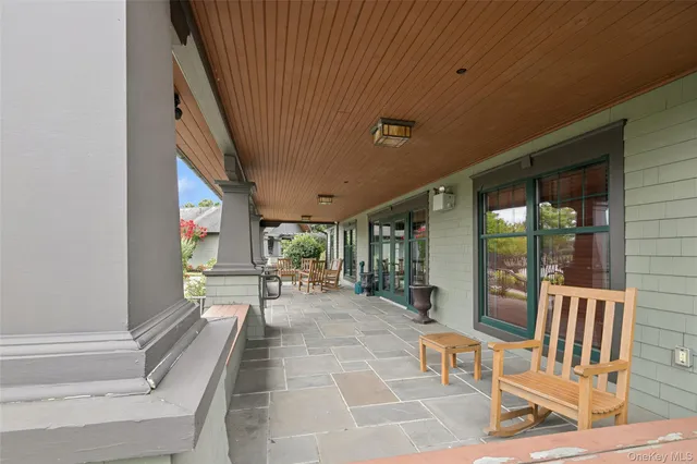 a view of a patio with table and chairs with wooden floor and fence