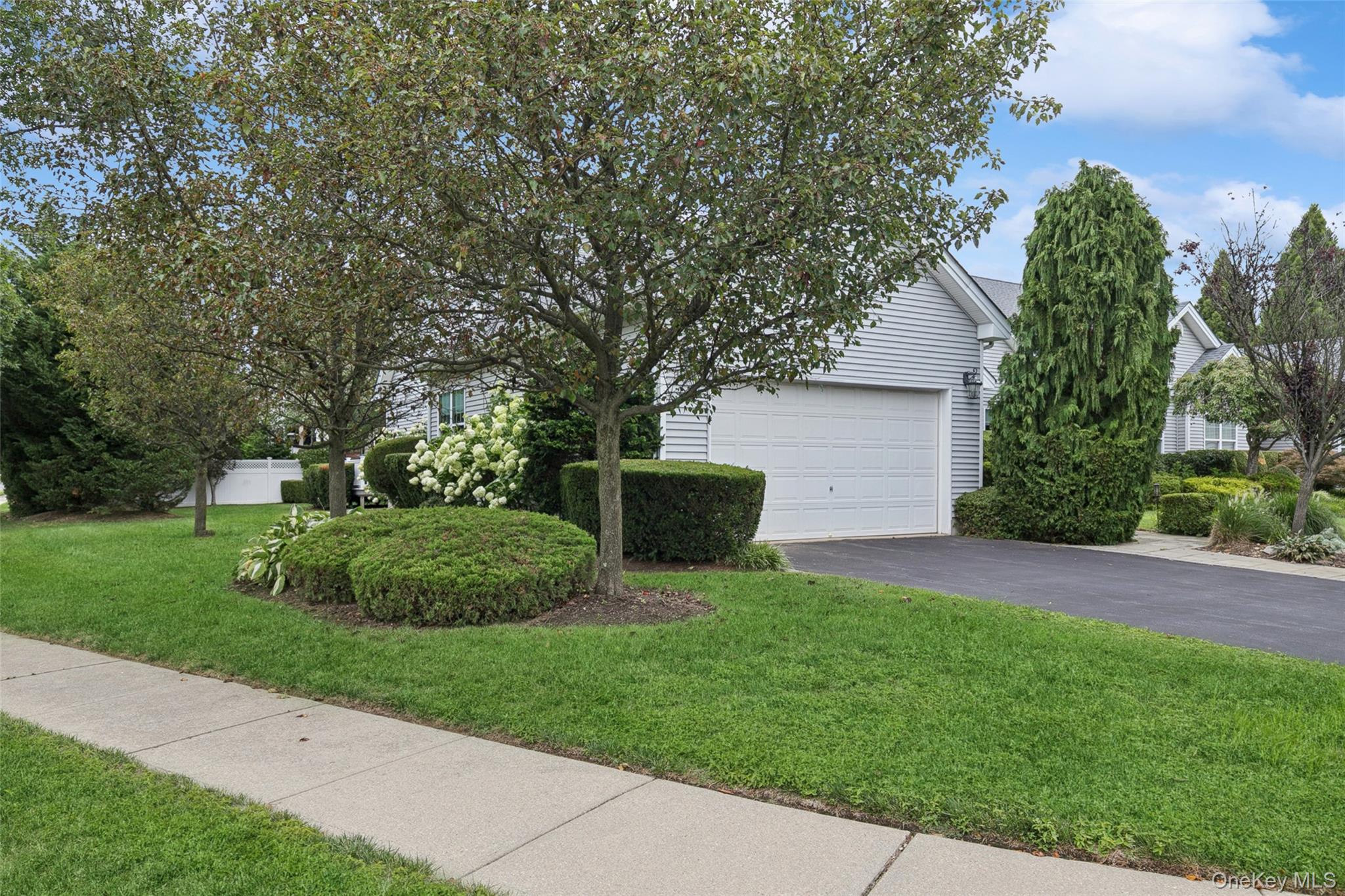 103 Rivendell Court Melville, NY 11747 - Photo 45 of 47 View of property exterior featuring driveway and a yard