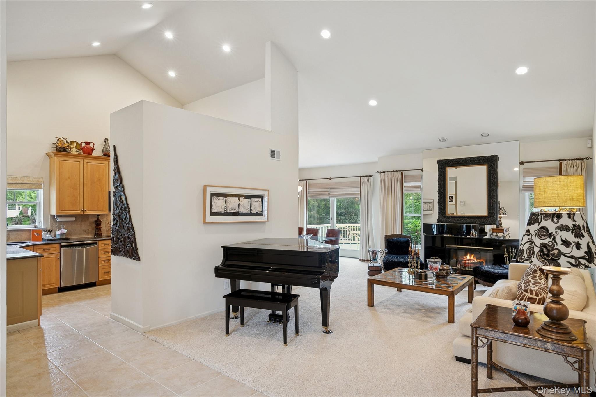 103 Rivendell Court Melville, NY 11747 - Photo 5 of 47 Living room with high vaulted ceiling, a glass covered fireplace, recessed lighting, plenty of natural light, and light tile patterned floors