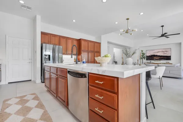 a kitchen with stainless steel appliances kitchen island granite countertop a sink stove and cabinets