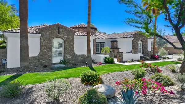 a front view of a house with a yard and potted plants