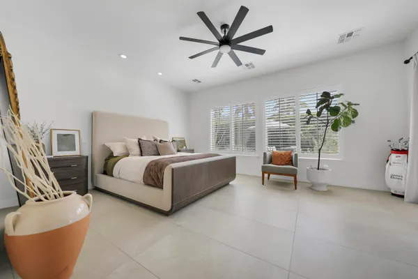 a bedroom with a bed a couch and a potted plant