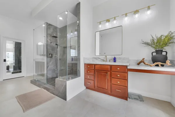 a bathroom with a granite countertop sink mirror and shower