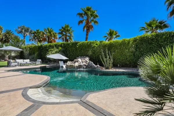 a patio with a table and chairs under an umbrella
