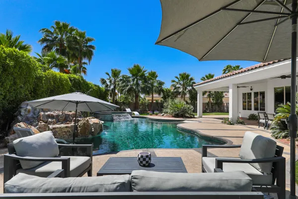 a view of a patio with a table and chairs under an umbrella
