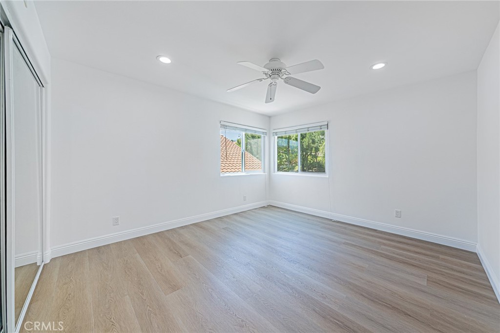 25533 Longfellow Place Stevenson Ranch, CA 91381 - Photo 29 of 47 an empty room with wooden floor chandelier fan and windows