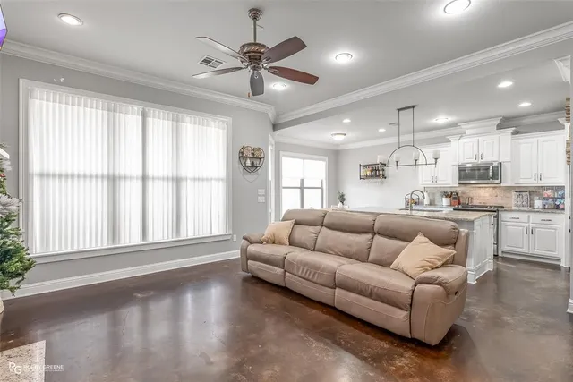 a living room with furniture and a large window with kitchen view
