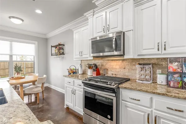 a kitchen with granite countertop white cabinets and appliances