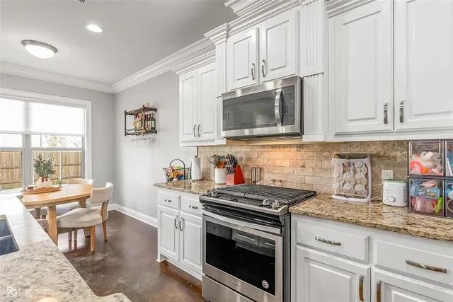 a kitchen with granite countertop white cabinets and appliances
