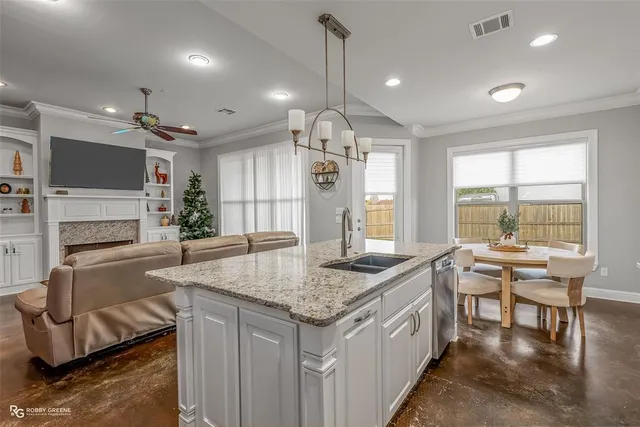 a kitchen with granite countertop a sink a counter top space and stainless steel appliances