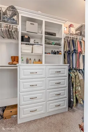 a view of walk in closet with clothes and shoes
