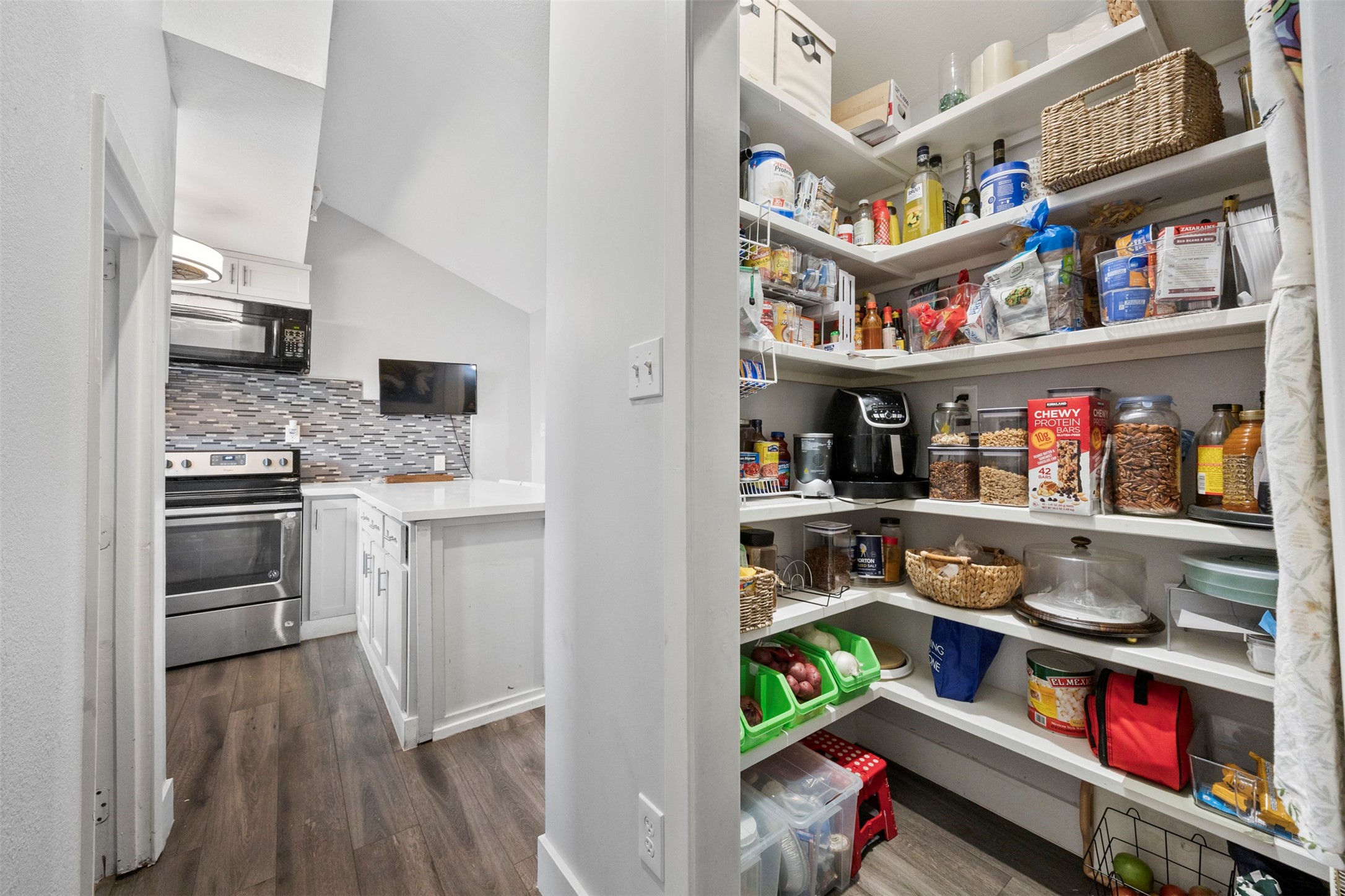 10430 Caxton Street Houston, TX 77016 - Photo 13 of 26 a kitchen with stainless steel appliances a refrigerator and a wooden floor