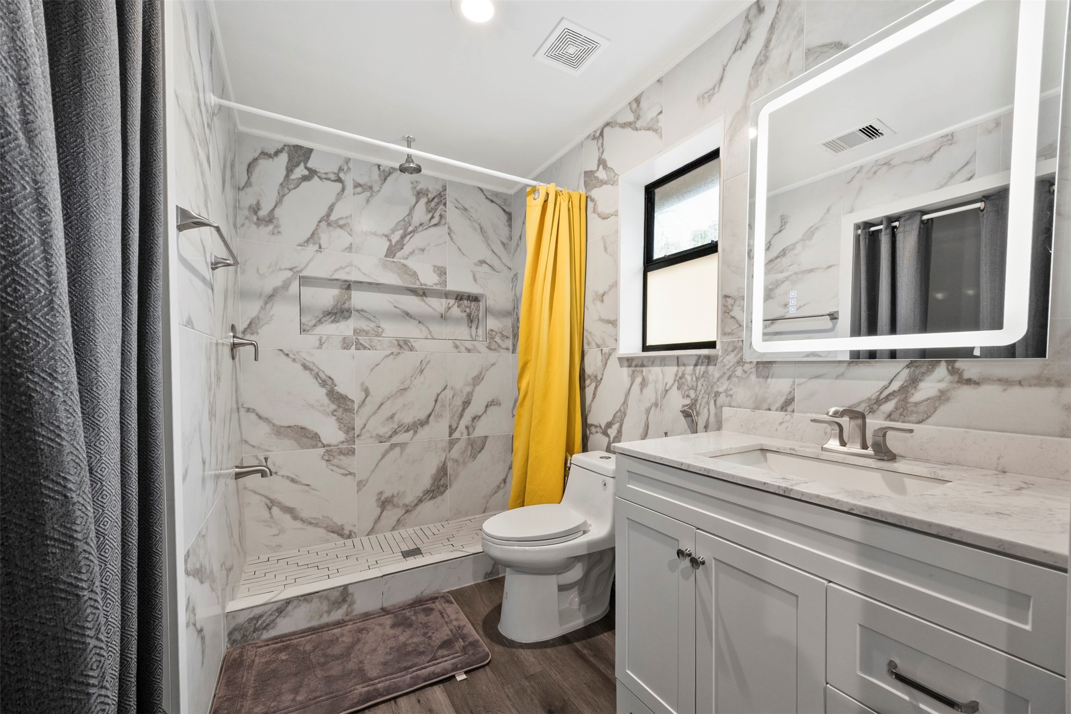10430 Caxton Street Houston, TX 77016 - Photo 7 of 26 a bathroom with a granite countertop sink a toilet and a shower curtain
