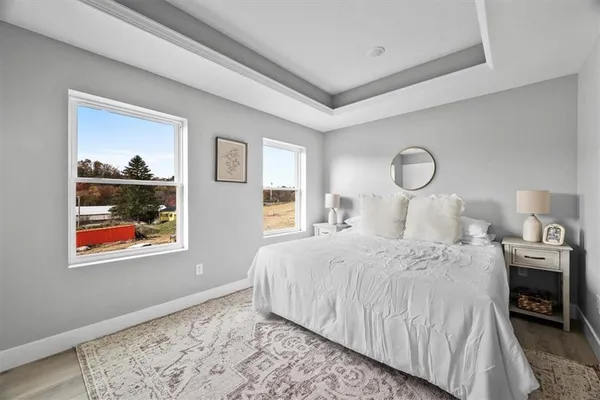 a bedroom with bed and wooden floor