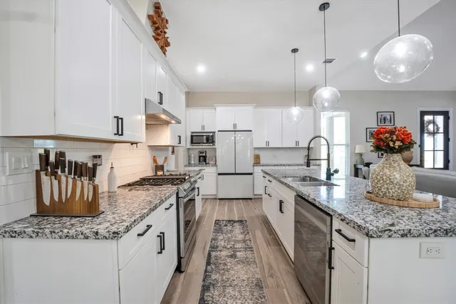 a large kitchen with granite countertop a lot of counter space and stainless steel appliances