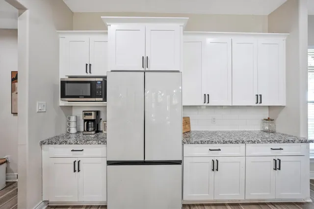 a kitchen with appliances a sink and cabinets