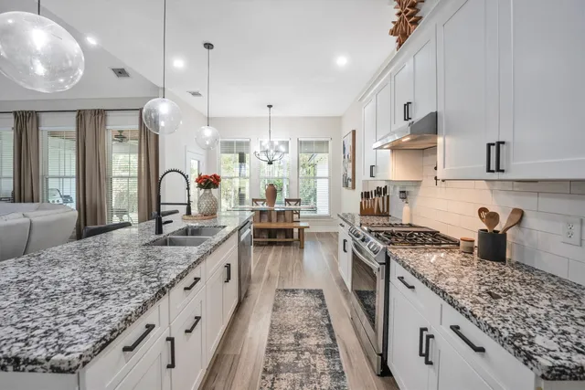 a large kitchen with kitchen island a large counter space a sink appliances and cabinets