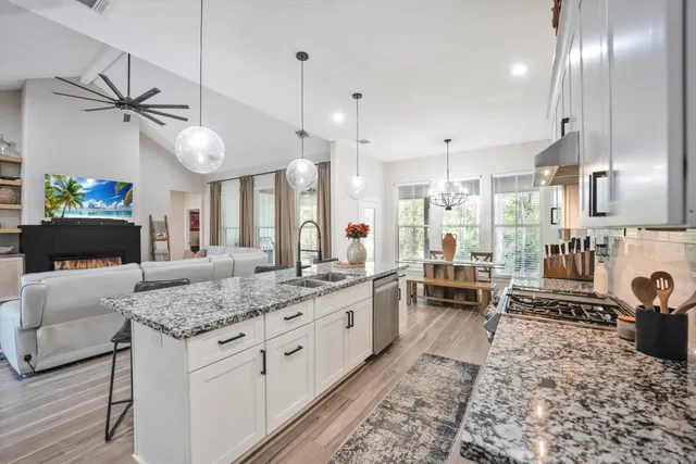 a large kitchen with kitchen island a large counter space a sink stainless steel appliances and cabinets