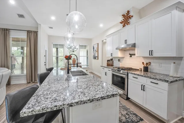 a kitchen with stainless steel appliances granite countertop a sink stove and refrigerator