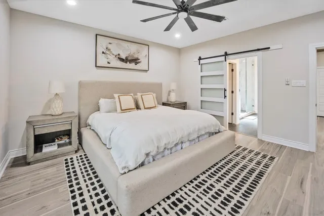 a bedroom with a large bed and a chandelier