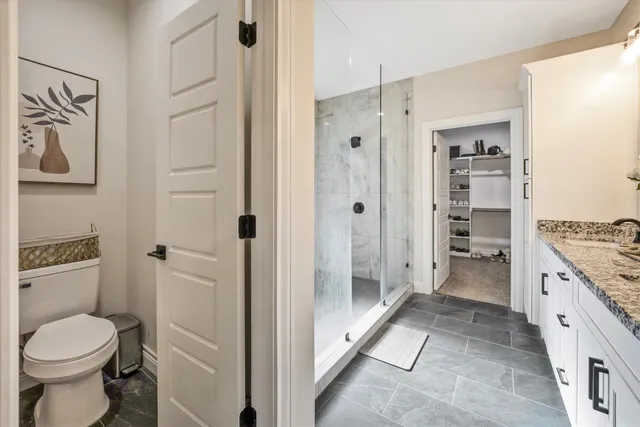a bathroom with a granite countertop toilet sink and shower