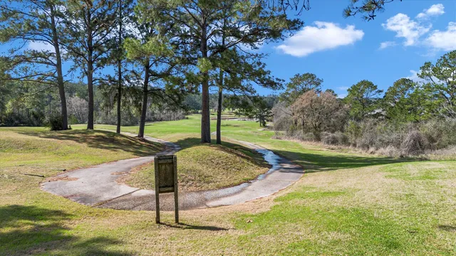 a view of a swimming pool with lawn chairs and a big yard